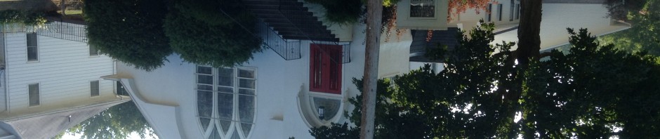 A white church building with a red door and large windows.