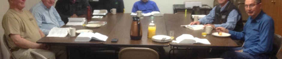 A group of people seated around a table in a meeting room.