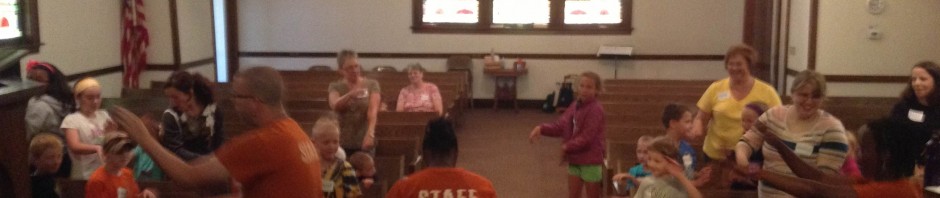 Children and adults engaged in activities inside a church hall.