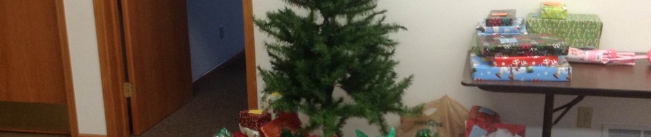 Christmas tree with wrapped presents underneath in a cozy home setting.