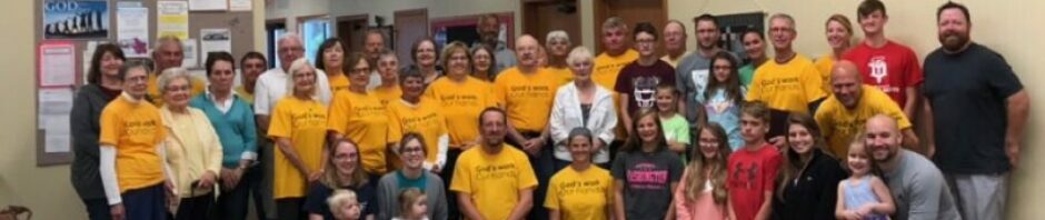 Group photo of people wearing yellow shirts with text.