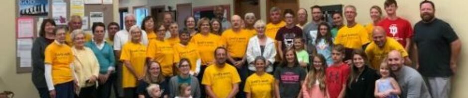 Group photo of people wearing matching yellow shirts.