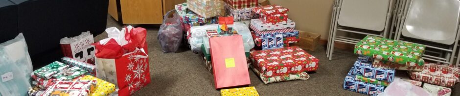 A room with various wrapped Christmas presents on the floor.