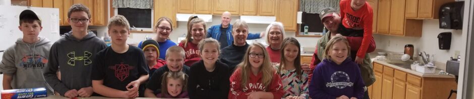 Group of people smiling behind a counter with festive decorations.