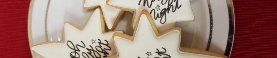 Star-shaped cookies with holiday messages on a white plate.
