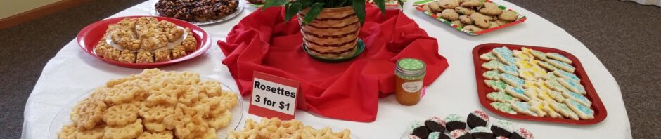 A table with various cookies and a plant centerpiece.