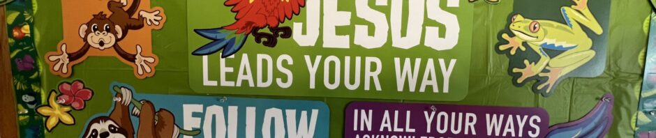 Colorful religious bulletin board with animals and a message about Jesus leading the way.
