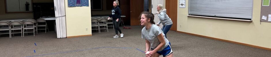 Young girl playing indoor basketball, focused on the game.