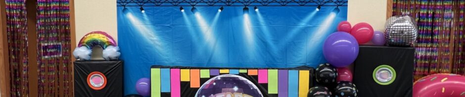 Colorful disco-themed party setup with balloons and vibrant dance floor.