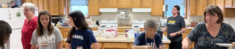Children and adults enjoying a colorful party at a kitchen counter.