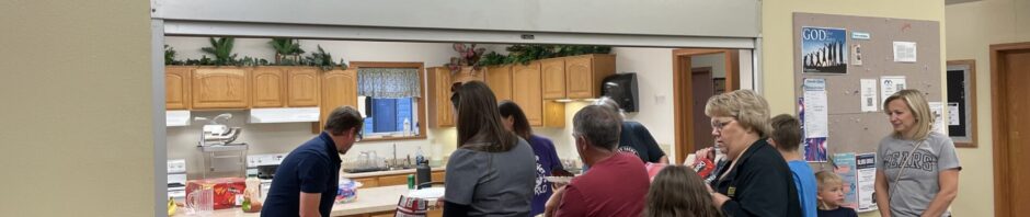 Families and individuals receiving meals at a church food pantry.
