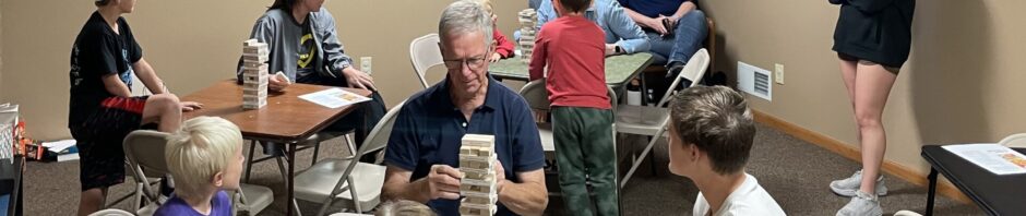 People gathered in a room playing card games and socializing.